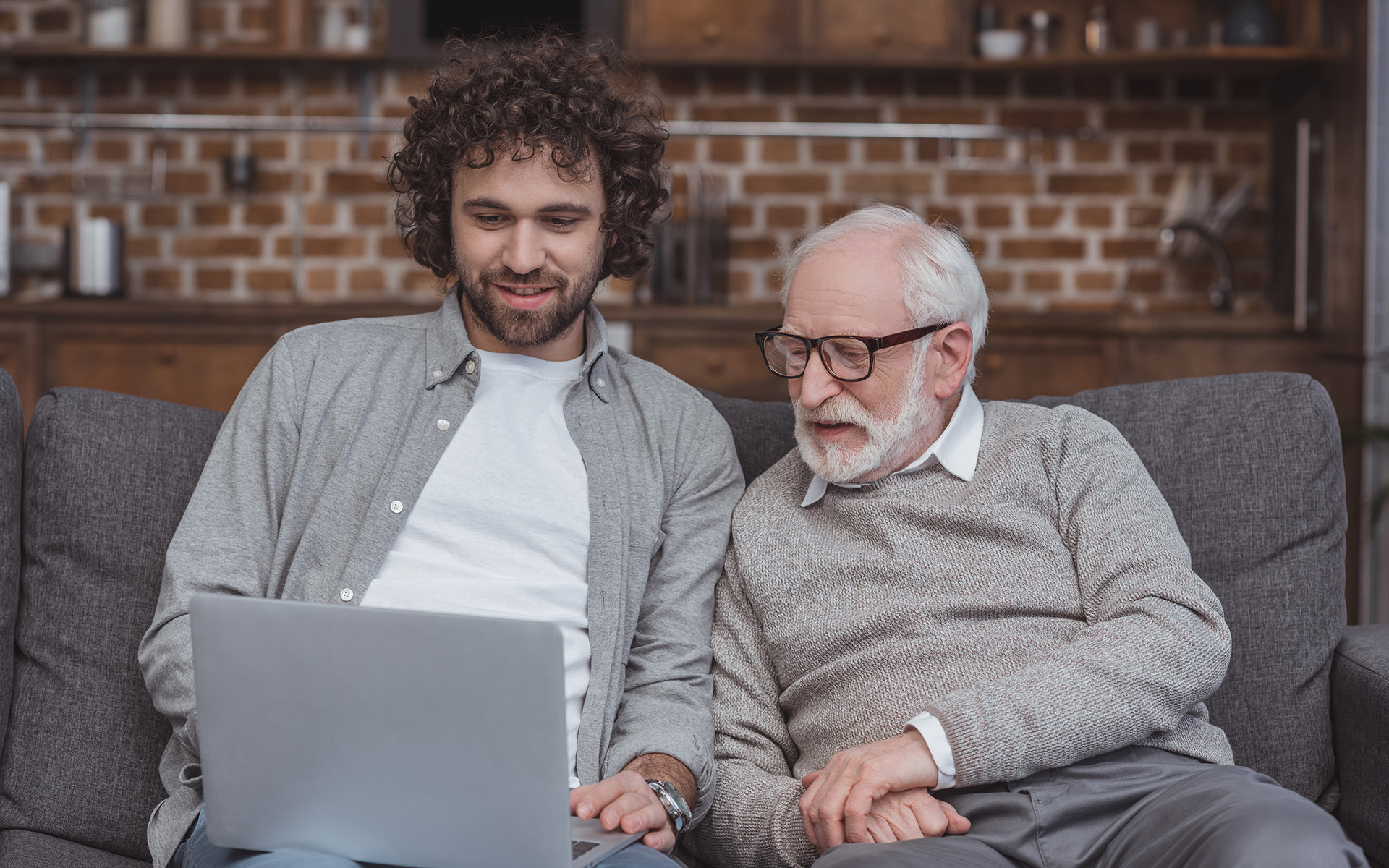 A father and adult son reviewing information together at home